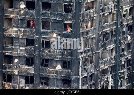 Such- und Rettungsteams durchsuchen die verkohlten Überreste des Turmes Grenfell in Latimer Road Stockfoto