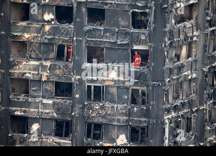 Such- und Rettungsteams durchsuchen die verkohlten Überreste des Turmes Grenfell in Latimer Road Stockfoto