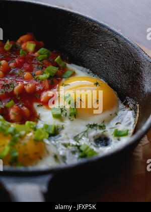 Nahaufnahme von Rührei mit roten Bohnen in einer Pfanne erhitzen. Englisches Frühstück im Café. Stockfoto