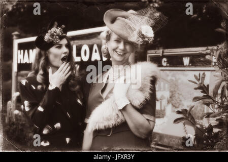 Zwei Damen in historischen Kostümen stehen auf der Plattform des Dampfes Bahnhof im Rahmen der Veranstaltung "Zurück in den 1940er Jahren" am Severn Valley Railway Stockfoto