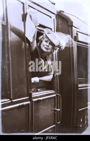 Reife Dame in Vintage Kostümen winken aus dem Fenster des Zuges Stockfoto