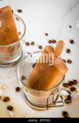 Sommer Desserts. Frozen Drinks serviert. Süße Eis am Stiel aus Kaffee und Milch hergestellt. In Kaffeetassen, auf einem weißen Marmortisch mit Kaffeebohnen. Textfreiraum Stockfoto