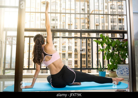 Mädchen beim Yoga auf dem Balkon zu Hause Stockfoto