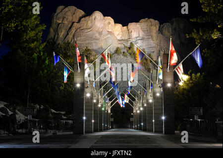 Internationale Fahnen Linie Grand View Eingang zum Mount Rushmore National Monument, wo vier ehemalige US-Präsidenten in der Nacht 24. März 2010 in Keystone, South Dakota in eine beleuchtete Granit-Felswand gehauen sind.     (Foto von Lance Cheung über Planetpix) Stockfoto