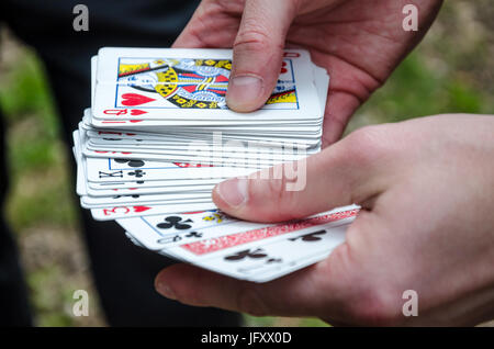 Eine Hand hält ein Kartenspiel. Stockfoto