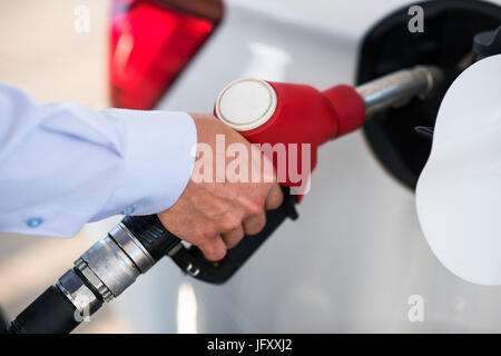 Betankung Pistole wird in den Tank des weißen Auto eingefügt. Stockfoto