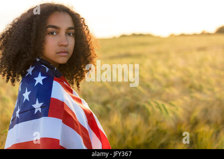 Traurig, deprimiert Mischlinge afroamerikanische Mädchen Teenager weibliche junge Frau mit Tränen in den Augen in einem Feld von Weizen oder Gerste Getreide halten und wrap Stockfoto