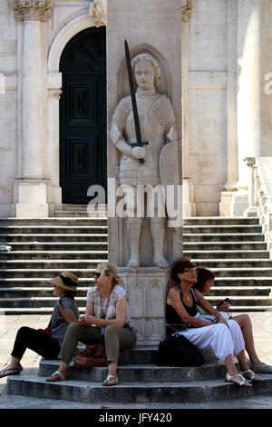 DUBROVNIK/Kroatien - 28. Juni 2017: Touristen sitzen in den Schatten unter Orlandos Colum vor der venezianischen Barock Kirche von Saint Blaise, Prot Stockfoto