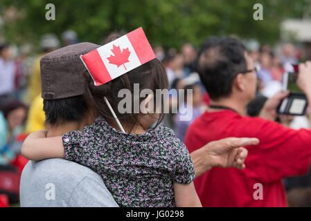 Edmonton, Alberta, Kanada, 1. Juli 2017. Kleines Kind mit kanadischen Flagge im Haar in einer großen Menschenmenge in Chinatown, Edmonton, Kanada. Bildnachweis: Jon Reaves/Alamy Live-Nachrichten Stockfoto