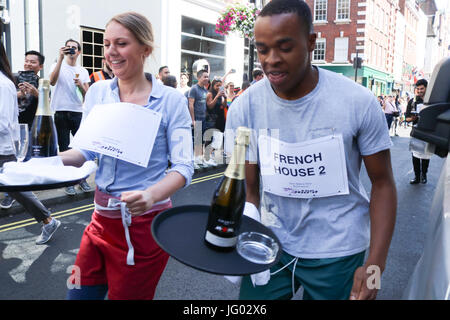 London UK. 2. Juli 2017.  Kellner nehmen Teil in der Soho-Kellner laufen mit einem Tablett in der Hand, beladen mit einer Serviette, eine halbe Flasche Champagner und einem Sektglas, Beschaffung von Mitteln für neue Wohltätigkeitsorganisation der Kellner Unterstützungskasse für angeschlagene Kellner Credit: Amer Ghazzal/Alamy Live-Nachrichten Stockfoto