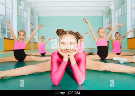 Porträt von niedlichen 11 Jahre altes Mädchen sitzen im Kreuz spaltet Position während der Gymnastik-Klasse Stockfoto