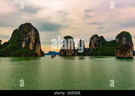 Ha Long Bucht, Vietnam--24. März 2016 Tour Boote Faden durch einen schmalen Durchgang zwischen den Felsformationen in Ha Long Bucht, Vietnam. Stockfoto