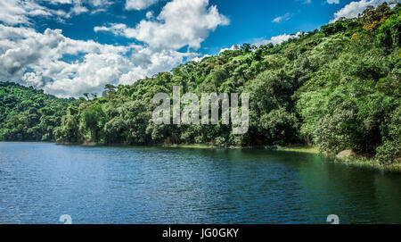 Schöne Landschaft eines blauen Himmels Nachdenken über einen See mit tief grünen Bäumen Stockfoto