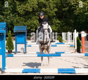 Mädchen mit roan Pony springen über die Hürde springen Wettbewerb Stockfoto