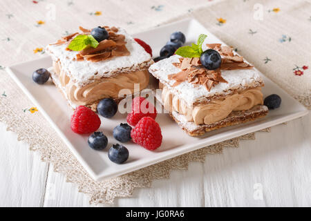 Schokoladenkuchen mit Himbeeren und Heidelbeeren Nahaufnahme auf einer Platte geschnitten. horizontale Stockfoto