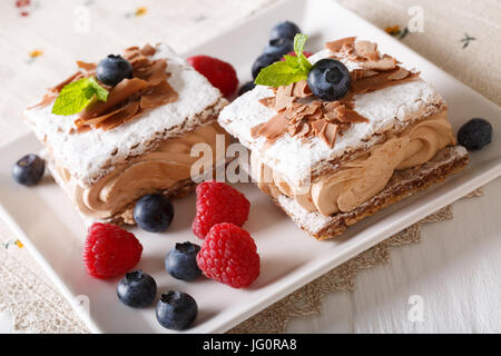 köstliche Schokolade Millefeuille mit Himbeeren und Heidelbeeren Nahaufnahme auf einer Platte. horizontale Stockfoto