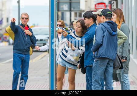 Japanische Touristen betrachten eine Straßenkarte in einer Stadt, um Richtungen zu finden. Stockfoto