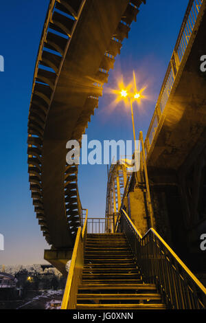 Verlassene Fußgängerbrücke in der Nacht in der Beleuchtung von Straßenlaternen in der Stadt Dnipropetrowsk, Ukraine Stockfoto