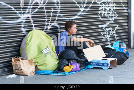 Obdachlose Frau sitzen draußen auf den Straßen in Brighton, East Sussex, England, UK. Stockfoto