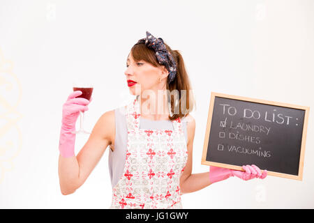 Hausfrau mit schwarzen Tafel mit einer Liste und Glas Wein in der Hand Stockfoto