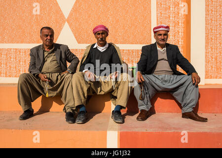 Traditionelle kurdische gekleidete Männer sitzen im Stadt Zentrum Al-Kosch für ihre Morgen Chat, Irak-Kurdistan Stockfoto