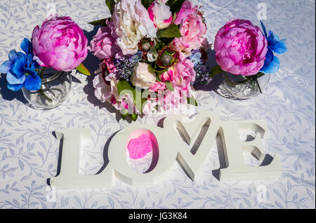 Kreative Layout mit bunten Blumen, Blättern und Wort Liebe. Liebe-Konzept. Stockfoto