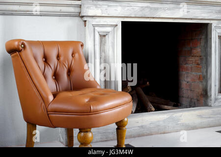 braune Ledersessel vor Kamin Stockfoto
