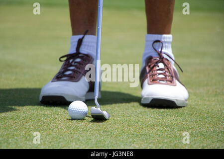 Golfer setzen Ball auf grün Stockfoto