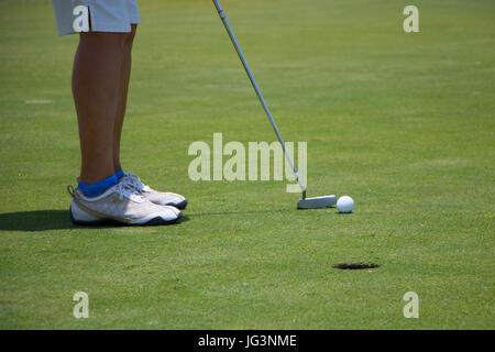 Golfer setzen Ball auf grün Stockfoto