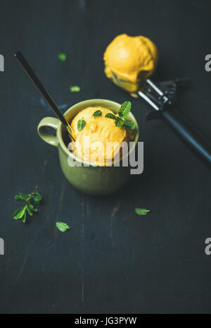 Mango-Sorbet Eisportionierer mit frischer Minze in Tasse Stockfoto