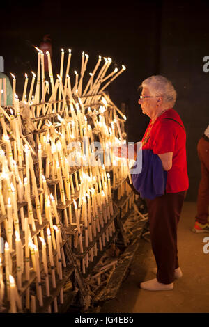 El Rocio, Spanien - 2. Juni 2017: Weibliche Pilger leuchtet Kerzen in der Einsiedelei von El Rocio während die Romeria 2017. Andalusien, Spanien Stockfoto