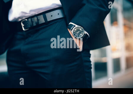 Nahaufnahme von Unternehmen die Hand eines Mannes eine Uhr zu tragen. Hand in der Tasche mit Armbanduhr. Stockfoto