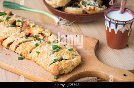 Blätterteig mit Pizzazutaten und in Scheiben geschnittenen Zwiebeln Stockfoto