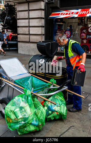 Ein Rat Arbeiter sammelt Müll von einem Lagerplatz, Piccadilly Circus, London, UK Stockfoto