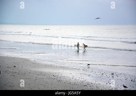 Surfer auf eine lange Strecke von Muizenberg Beach an der False Bay, Cape Town South Africa Stockfoto