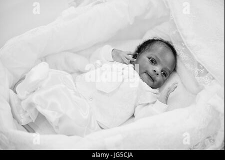 Kleine winzige afroamerikanische Neugeborenes mit auf dem Bett. Schwarz / weiß Foto. Stockfoto