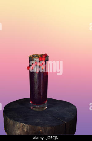 Detox ist ein Getränk, das aus den Beeren des Viburnum in Glas Tasse auf hölzernen Hintergrund im rustikalen Stil mit Textfreiraum. Isoliert. Die vertikalen Rahmen. Stockfoto