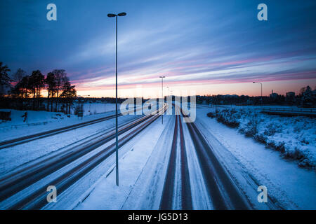 Und fast leeren Autobahn an einem kalten Winterabend in Finnland Stockfoto