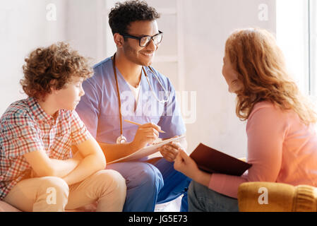 Lächelnd medizinische Arbeiter Beratung Mutter seines Patienten Stockfoto