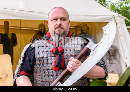 Ein großer Mann hält eine große, gefährliche mittelalterlichen scharfe scharfe Axt. Stockfoto