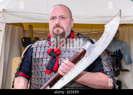 Ein großer Mann hält eine große, gefährliche mittelalterlichen scharfe scharfe Axt. Stockfoto