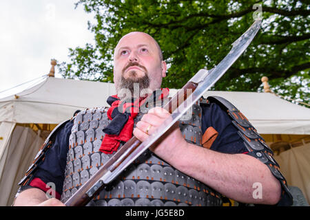 Ein großer Mann hält eine große, gefährliche mittelalterlichen scharfe scharfe Axt. Stockfoto