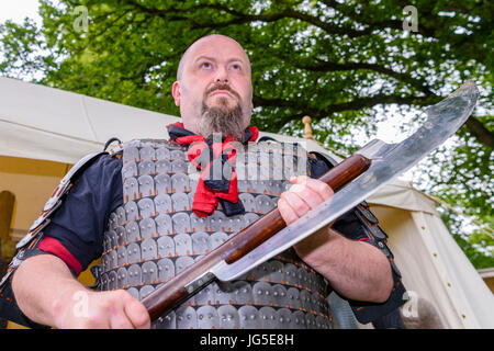 Ein großer Mann hält eine große, gefährliche mittelalterlichen scharfe scharfe Axt. Stockfoto