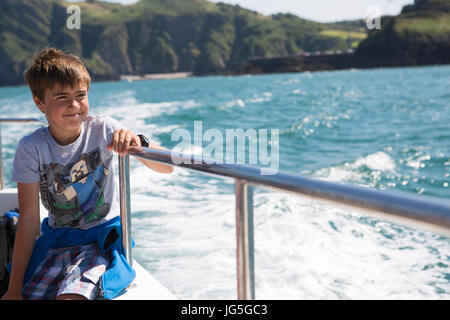 Ein Junge auf einem Boot, Blick auf das Meer, Devon UK Stockfoto