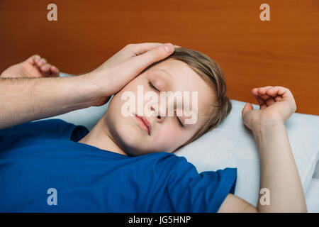 Porträt des kleinen Jungen schlafen im Bett mit Vater in der Nähe von Stockfoto