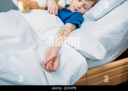 Porträt des kleinen Jungen mit Drop-Zähler im Krankenhausbett schlafen Stockfoto