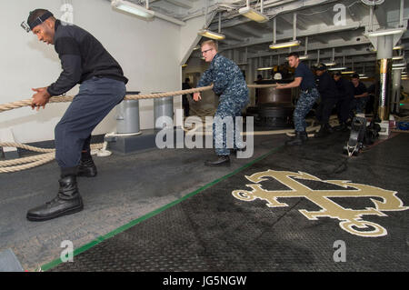 170703-N-DL434-027 SYDNEY (3. Juli 2017) Segler hieven eine Befestigungsleine auf dem Vorschiff der amphibischen Angriff Schiff USS Bonhomme Richard (LHD-6), als das Schiff fährt von Sydney nach einem viertägigen Hafen-Besuch und zur Teilnahme an Talisman Saber 2017 bereitet. Talisman Saber ist ein alle zwei Jahre in den USA-Australien bilaterale militärische Übung, die ein Feld Trainingsübung und Stabsrahmenübung, Interoperabilität und Reaktion, die Grundsätze der USA zu wahren Stärken kombiniert-australische Allianz. (US Navy Foto von Masse Kommunikation Spezialist Seemann Lehrling Gavin Schilde/freigegeben Stockfoto