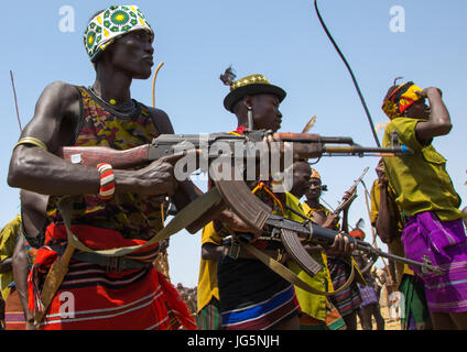 Männer mit Waffen während der Zeremonie stolz Ochsen in den Dassanech Stamm, Turkana County, Omorate, Äthiopien Stockfoto