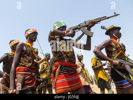 Mann mit einer Kalaschnikow schießen, während der Zeremonie stolz Ochsen in den Dassanech Stamm, Turkana County, Omorate, Äthiopien Stockfoto