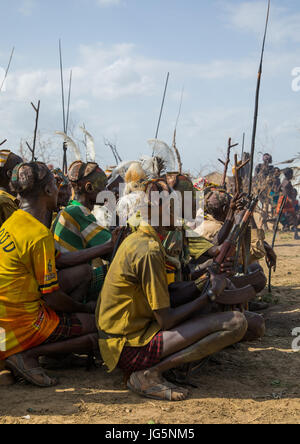 Stamm Krieger während der Zeremonie stolz Ochsen in den Dassanech Stamm, die darauf warten, das Kuh-Fleisch, Turkana County, Omorate, Äthiopien teilen Stockfoto